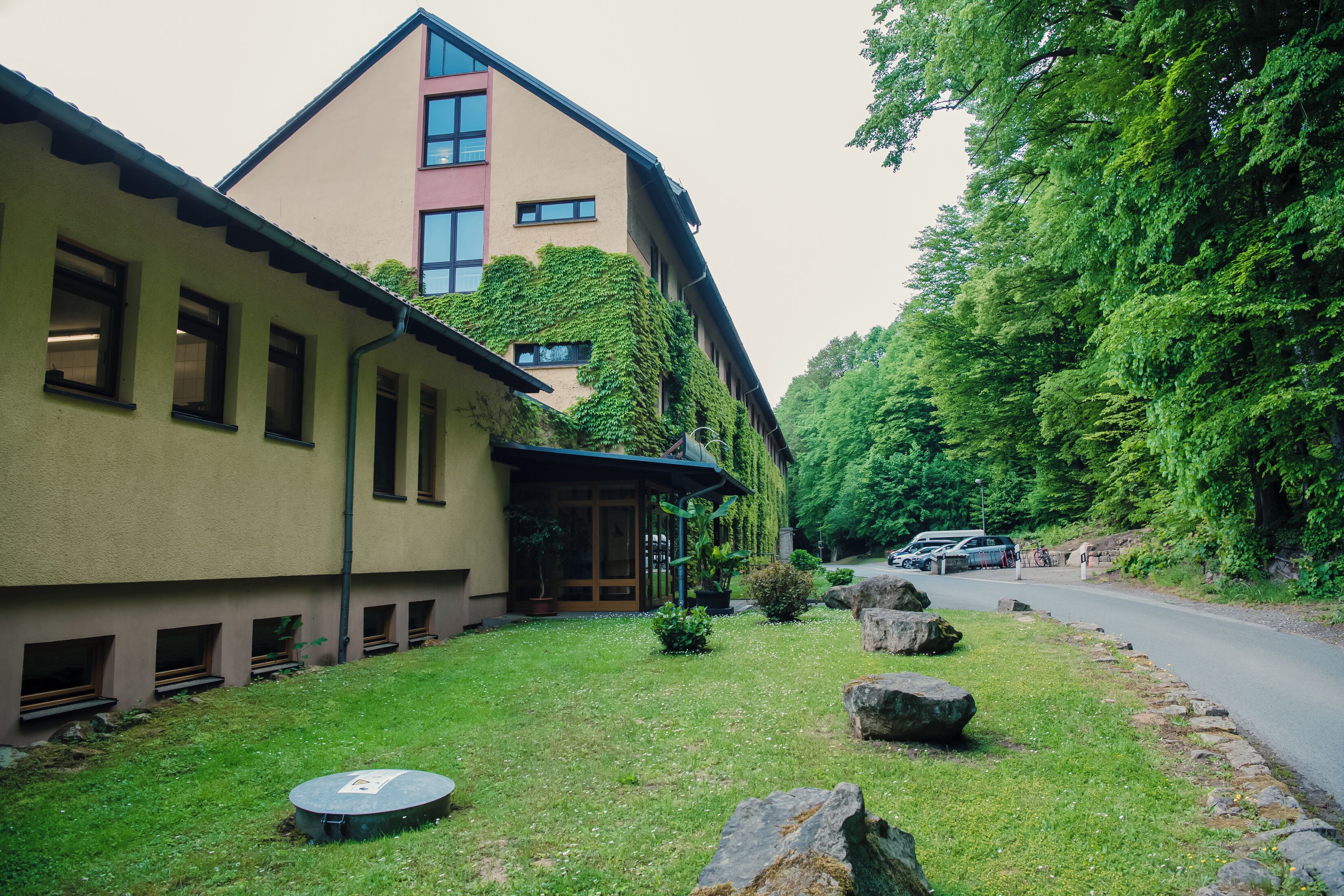 Un edificio de techo inclinado y un jardín con rocas y plantas.