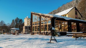 Een gebouw met grote ramen en een sneeuwbedekte dak, omgeven door een besneeerd landschap.
