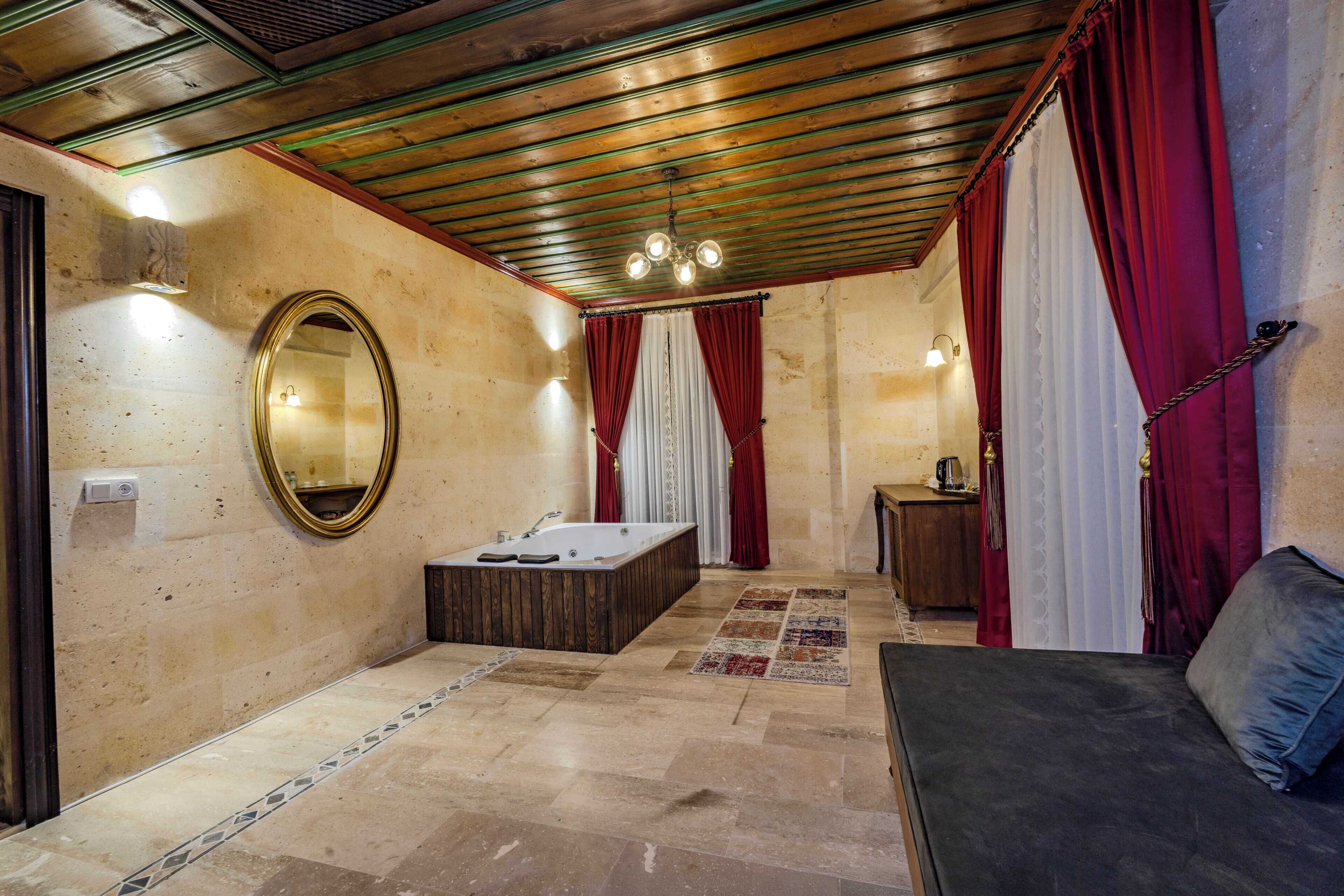 Un baño con bañera, espejo y banco de madera.