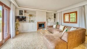 Una sala de estar con chimenea, sofá y televisor.