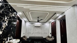A modern interior with a marble floor, a black and white patterned sofa, and a ceiling with recessed lighting.
