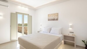 Un dormitorio con una cama grande, una mesita de noche, una lámpara de pared y un cuadro.