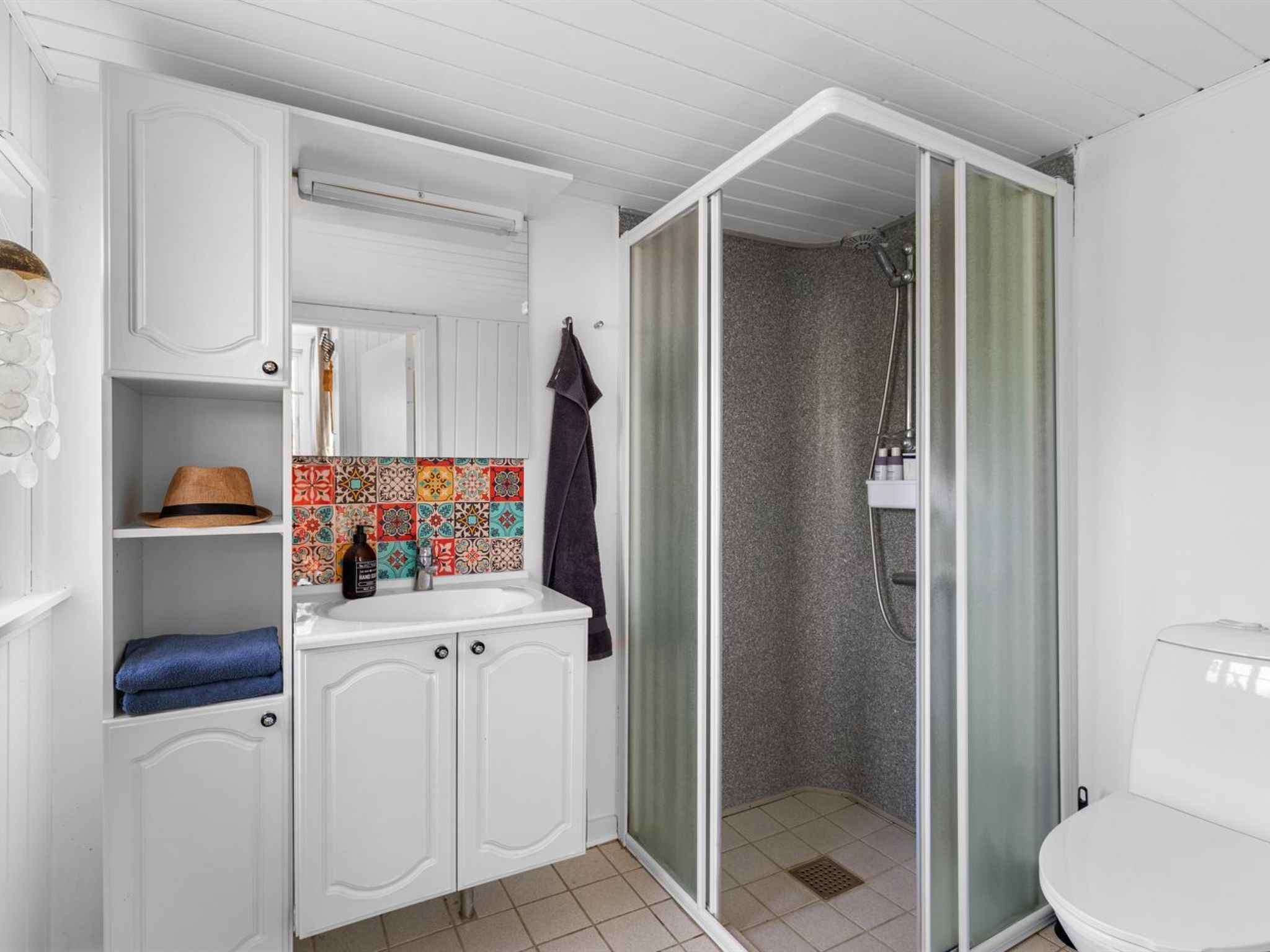 Une salle de bain avec une douche, un lavabo et des toilettes.