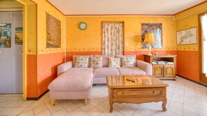 Ein Wohnzimmer mit einer Couch, einem Holztisch und einem Schrank.