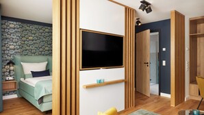 A modern bedroom with a bed, a TV mounted on the wall, and a wooden wardrobe. - New opening 2025: Beautiful apartment with first-class furnishings! (Sankt Peter-Ording)