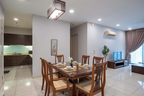Un comedor moderno con una mesa de madera dispuesta para cuatro personas, rodeada de sillas.