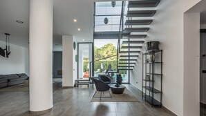 Een modern interieur met een trap, een zithoek en uitzicht op de omgeving.