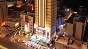 Un hôtel à plusieurs étages doté d’un atrium central et d’un parking pouvant accueillir plusieurs voitures.
