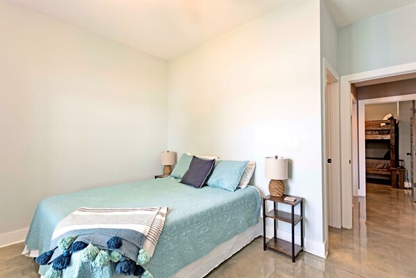 Un dormitorio con cama, mesitas de noche y un velador.