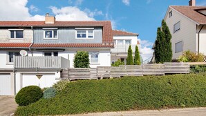 A residential building with a sloped roof, a satellite dish, and a gated entrance. - Apartment 'Ferienwohnung Steffi' with Private Terrace and Wi-Fi (Laichingen)