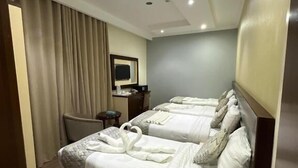 Una habitación de hotel con dos camas, un escritorio, una silla y un televisor.