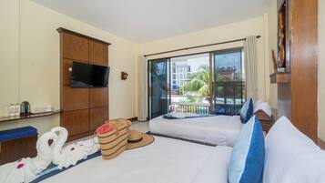 Habitación de hotel con una cama grande, televisión, minibar y vistas al exterior.
