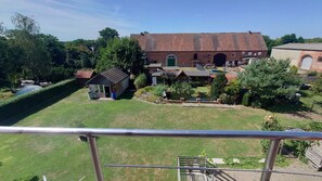 A large house with a garden, a small shed, and a pond.