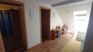 A room with wooden flooring, a desk with a lamp, and a window with a view of greenery. - Apartment 4 Zum Kuhstall Heinrichsberg - Magdeburg (Heinrichsberg)