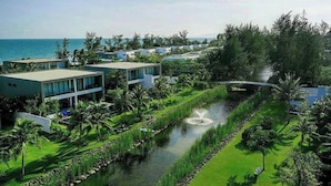 A resort with modern buildings, a water feature, and a view of the ocean. - Glenwood Sanctuary Villa 85 Ho Tram (Ho Chi Minh City)