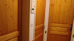 A wooden door with a white wall and a light switch. - Spacious Apartment in Super Besse for 6 with WIFI (Besse-et-Saint-Anastaise-Super Besse)