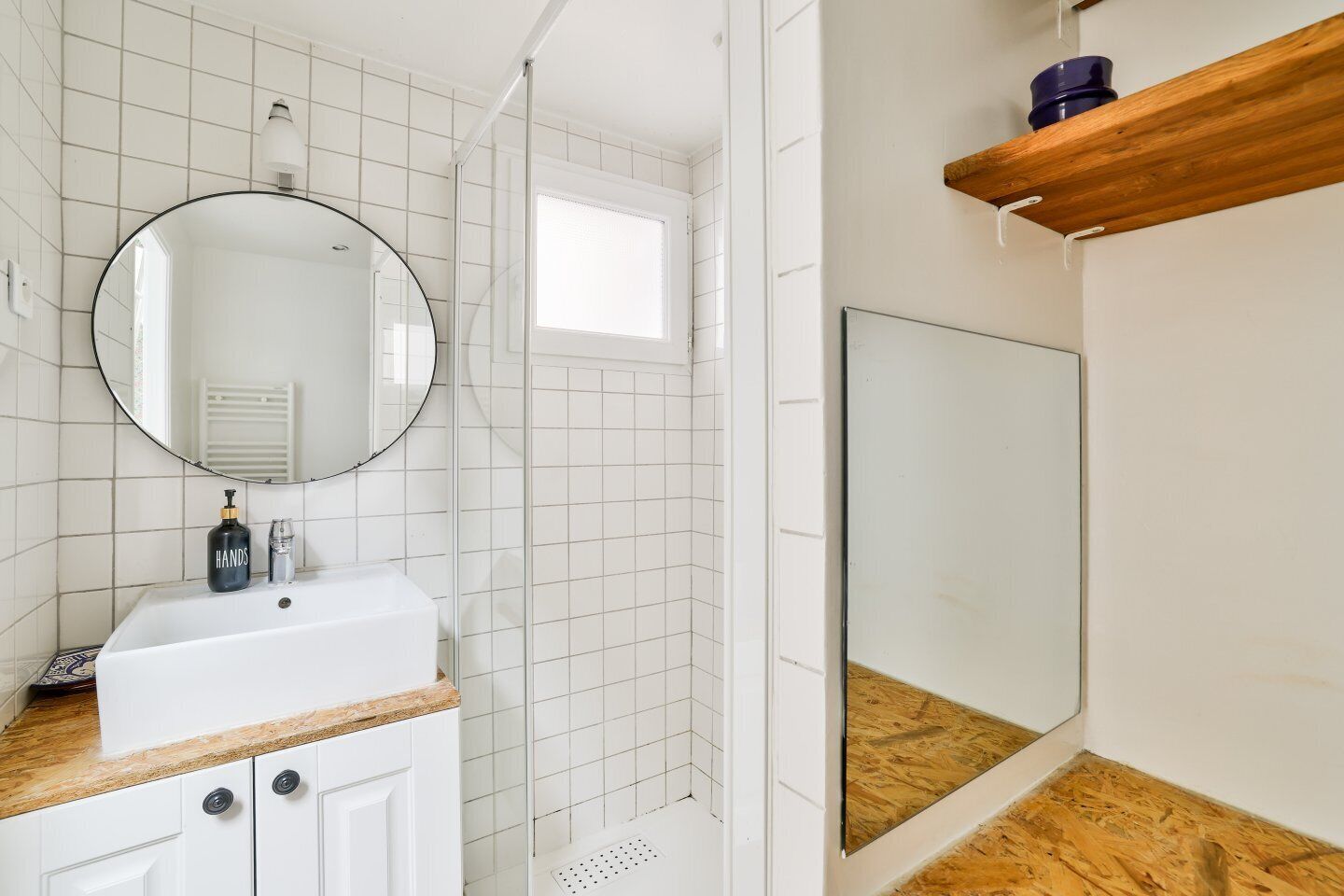 A bathroom with a white sink, a mirror, and a shower area.