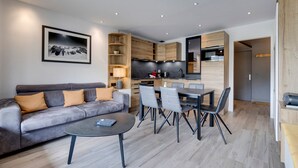 Una sala de estar moderna con un sofá gris, una mesa de centro y un comedor con sillas.