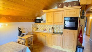 A compact kitchen with wooden cabinets, a microwave, and a small sink.
