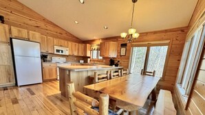 Une cuisine de style rustique, avec des éléments en bois, un îlot central, des chaises en bois et un banc.