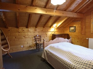 A cozy wooden cabin room with a bed, a chair, and a desk. - Typical Chalet 5 Bedrooms for 10 People with Wi-Fi and Terrace (Les Carroz d'Arâches)