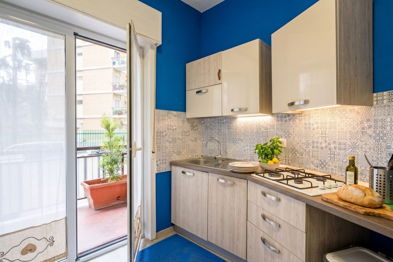 Una cucina con piano cottura a gas, lavello e pensili.