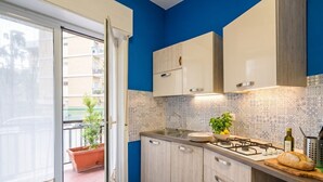 Una cucina con piano cottura a gas, lavello e pensili.