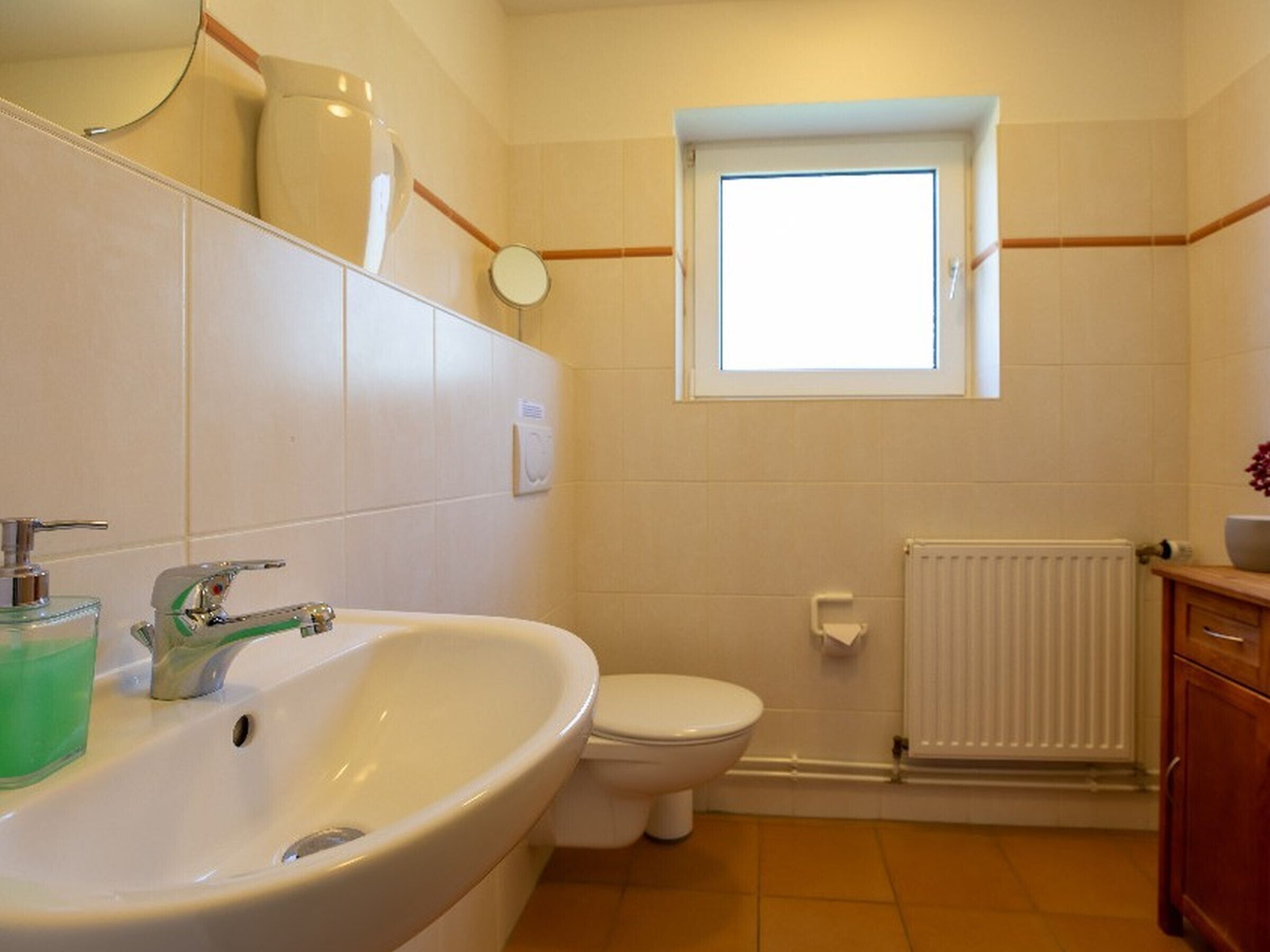 Un baño con lavabo, inodoro y ventana.