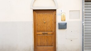 A wooden door with a brass handle, a mailbox, and a small plaque on the wall. - Oltrarno Art House - Florence (Firenze)