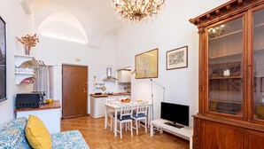 A compact living space with a kitchenette, dining area, and a television. - Central Apartment Porta Soprana Genova (Genoa)
