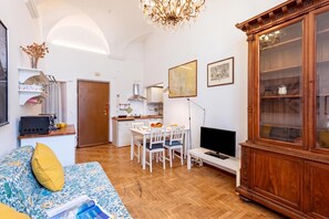 A compact living space with a kitchenette, dining area, and a television. - Central Apartment Porta Soprana Genova (Genoa)