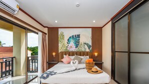 A modern hotel room with a large bed, a balcony, and a tropical-themed mural. - The Outdoor Kata (Karon)