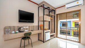 A modern kitchen with a built-in TV, a wooden counter, and a green chair. - The Outdoor Kata (Karon)