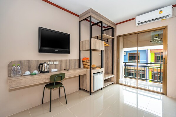 A modern kitchen with a built-in TV, a wooden counter, and a green chair. - The Outdoor Kata (Karon)