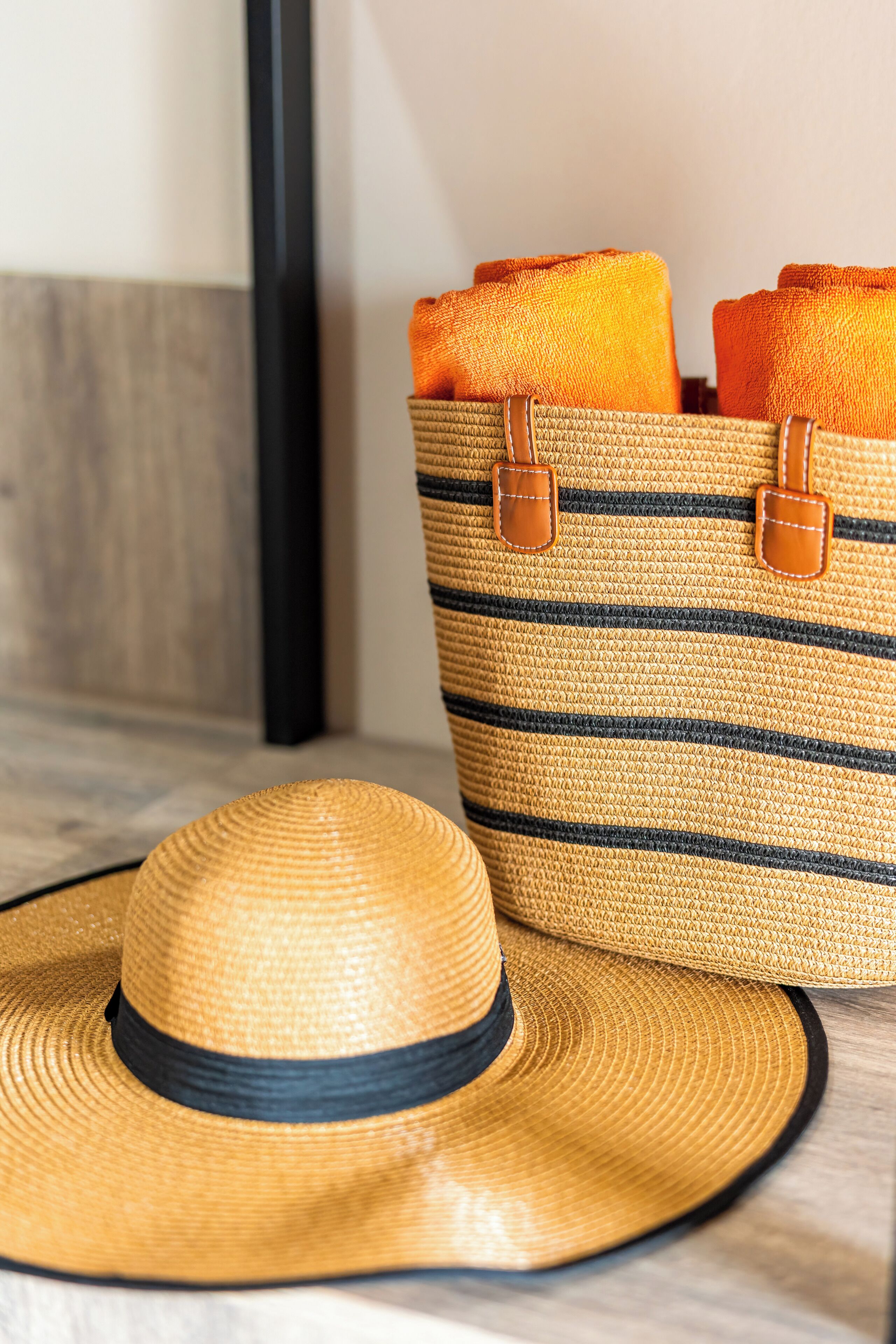 A straw hat and a striped woven bag with handles.