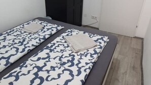 A single bed with a patterned bedspread, a dark-colored headboard, and a white door in the background. - Chic and Comfortable 1-Bedroom Stay in Vienna (Vienna)