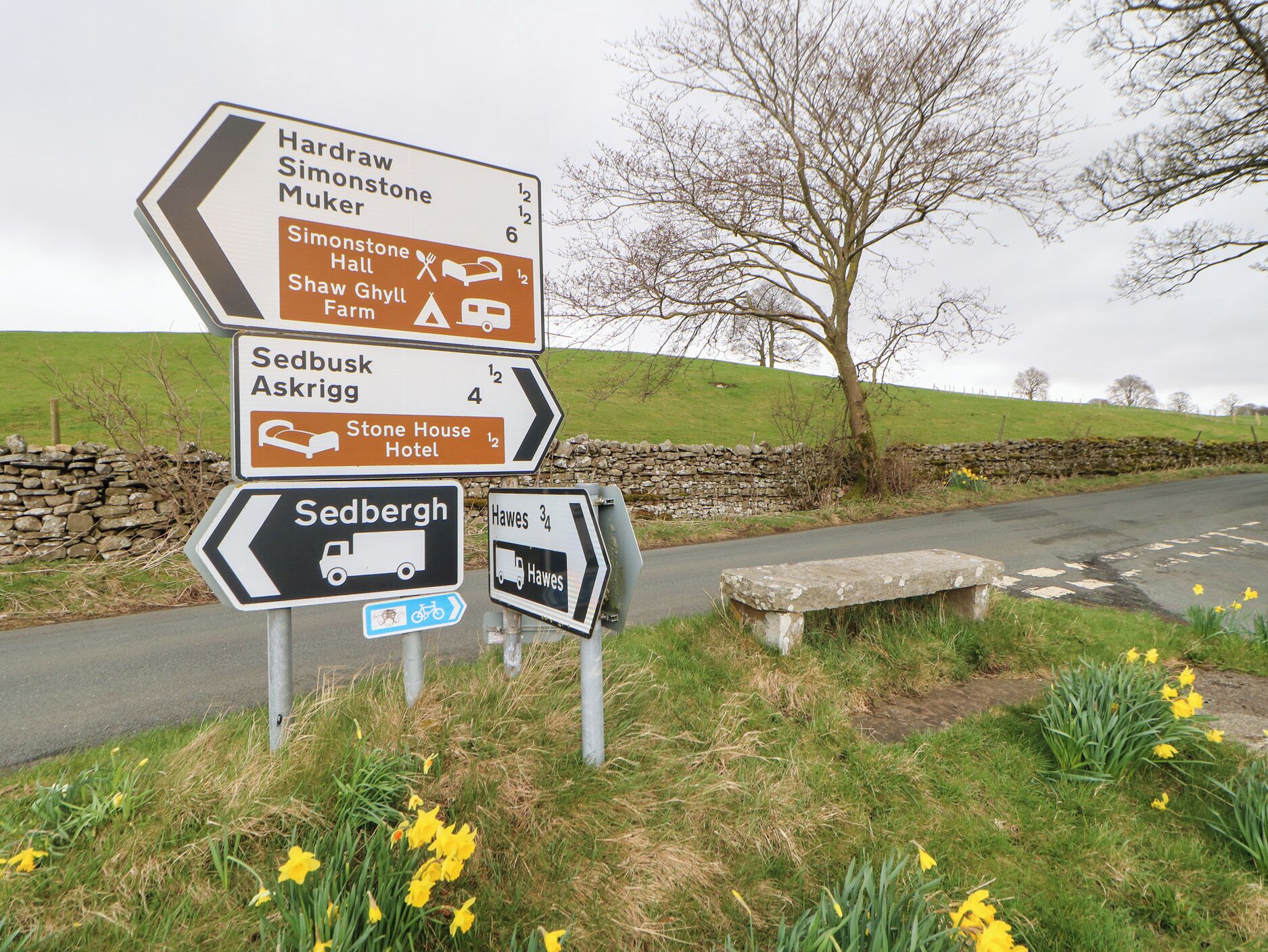 Un panneau de signalisation indiquant plusieurs destinations et les distances correspondantes.