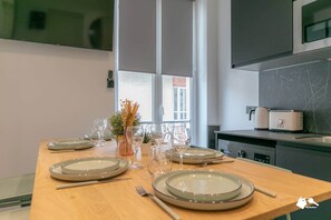 A modern kitchen with a wooden table set for dining, a toaster, and a microwave.