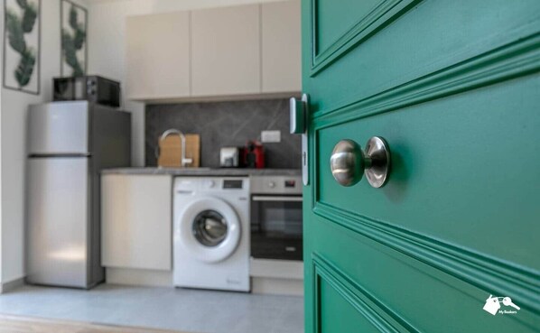 A kitchen with a washing machine, a refrigerator, and a microwave. - MBA - Diderot 3 - Splendid Apartment (Montreuil)