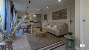 Un salon moderne avec un canapé, une table basse et un coin repas.