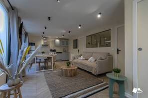 Un salon moderne avec un canapé, une table basse et un coin repas.