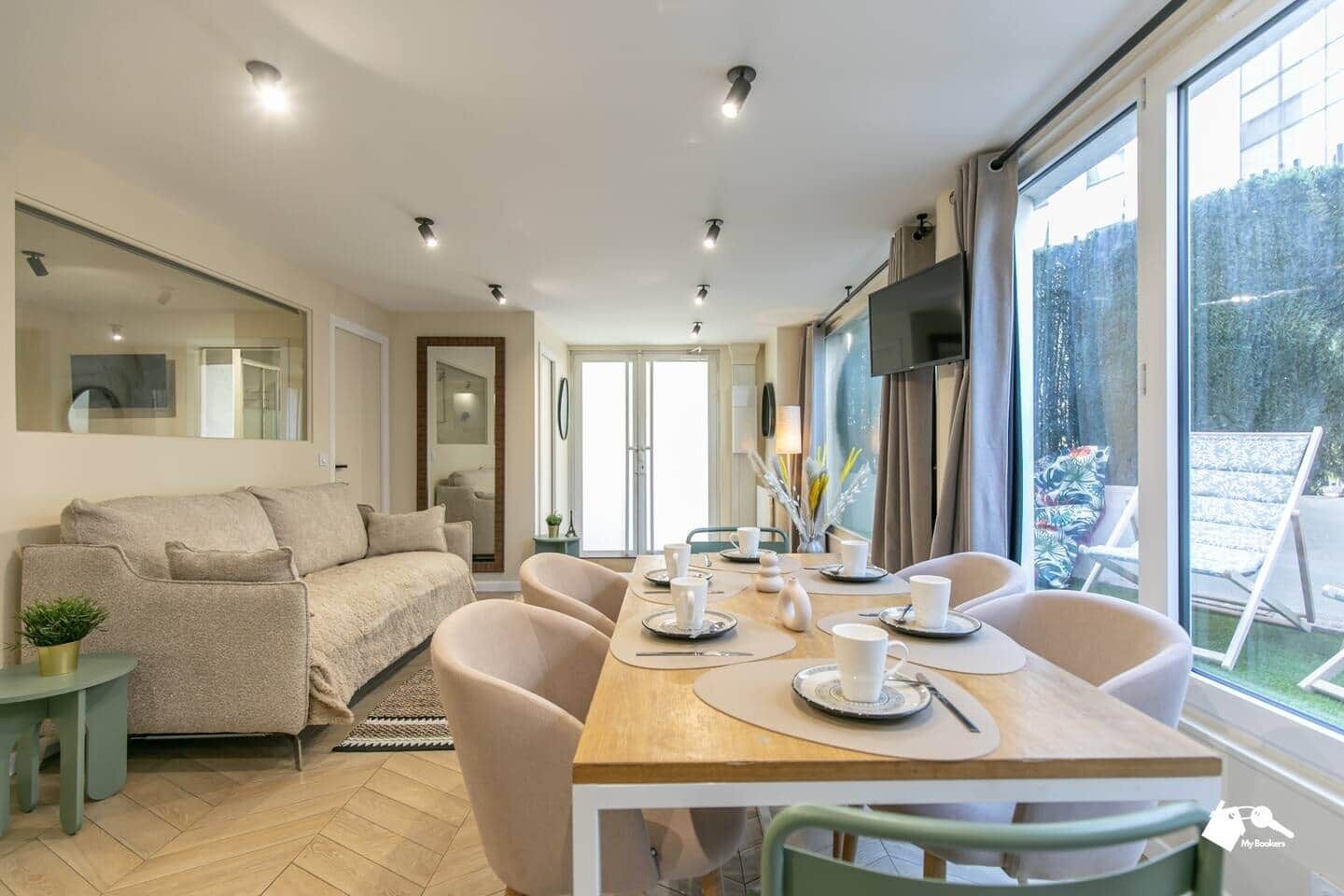 Een moderne woonkamer met een bank, eettafel, stoelen en een televisie.
