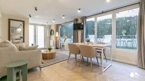 Un salon spacieux comprenant un canapé, une table à manger, des chaises et un téléviseur.