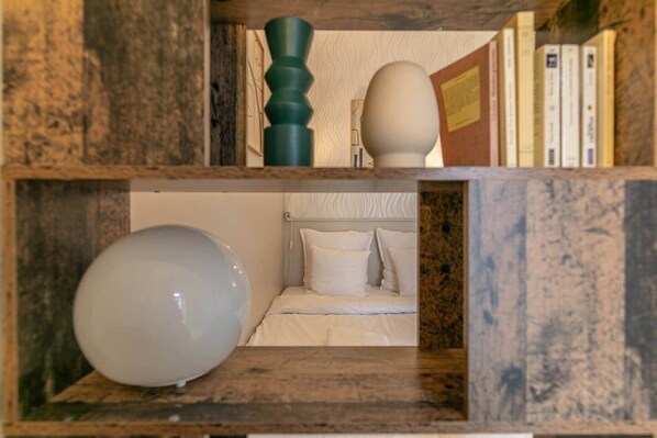 A bedroom with a bed, pillows, and a nightstand.