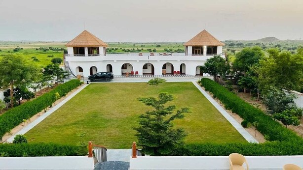 Un grand bâtiment blanc, doté de deux tours et d’une cour intérieure.