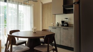 Une cuisine moderne avec une table à manger ronde, des chaises et un mixeur encastré.