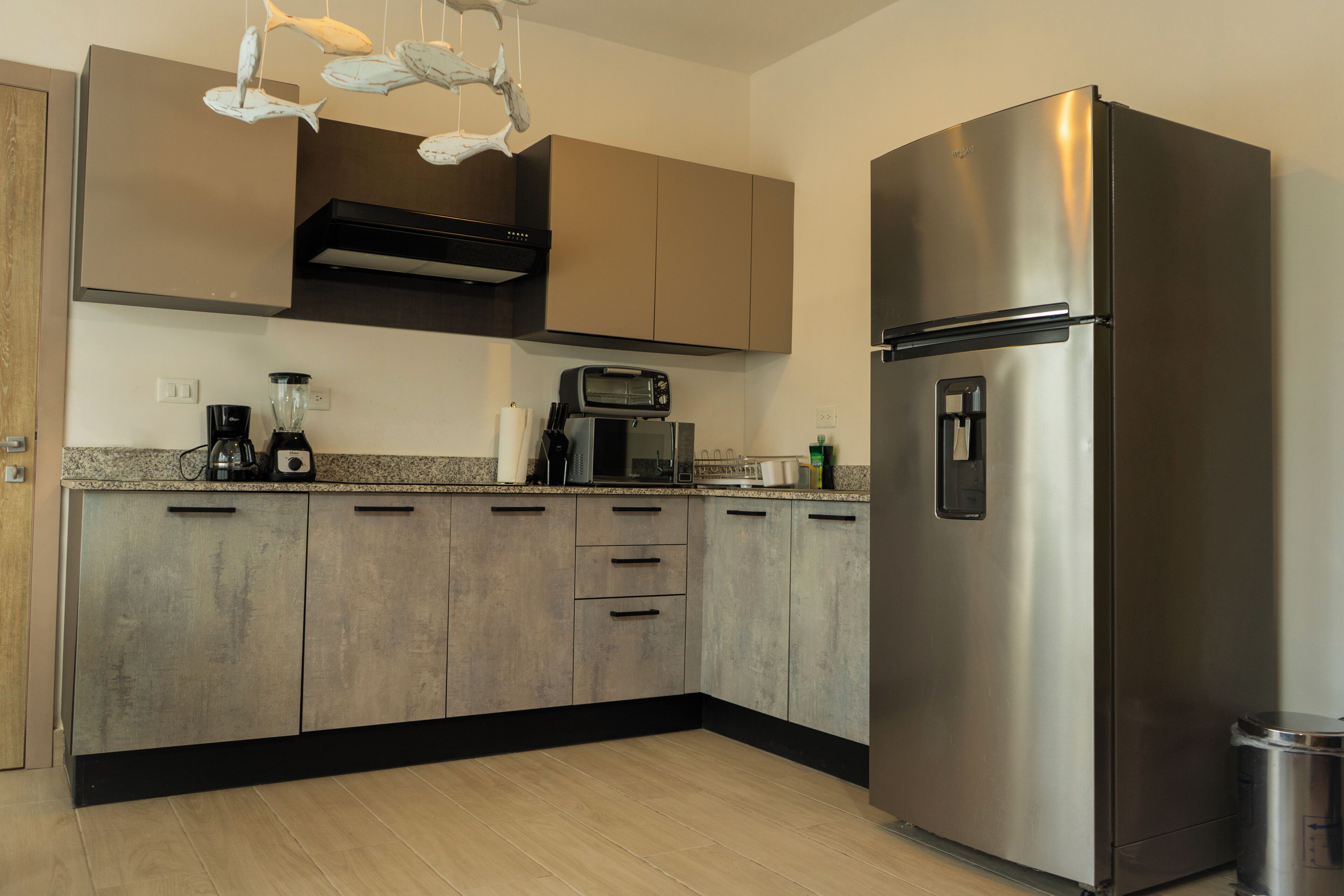 A modern kitchen with stainless steel appliances, wooden cabinets, and a built-in oven.