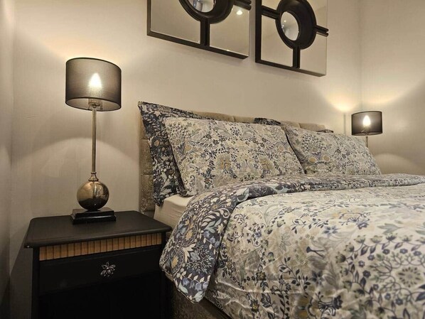A bedroom with a bed, two bedside tables, and wall art. - Stay Zen Apartments - Free Parking & Garden Woking (Woking)