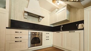 Een moderne keuken met houten kastjes, een zwart aanrecht en een roestvrijstalen oven.