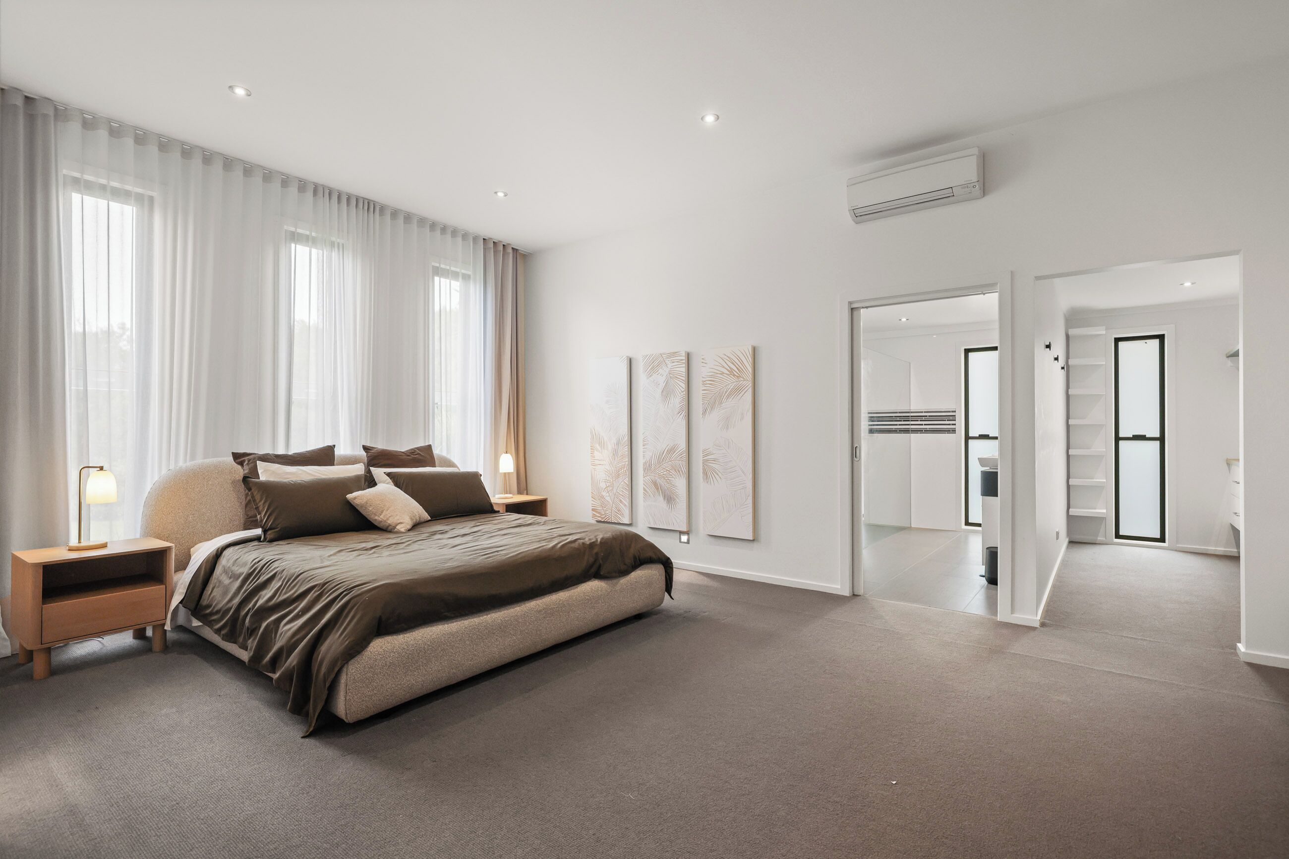 Quarto moderno com uma cama grande, mesas de cabeceira e um closet espaçoso.